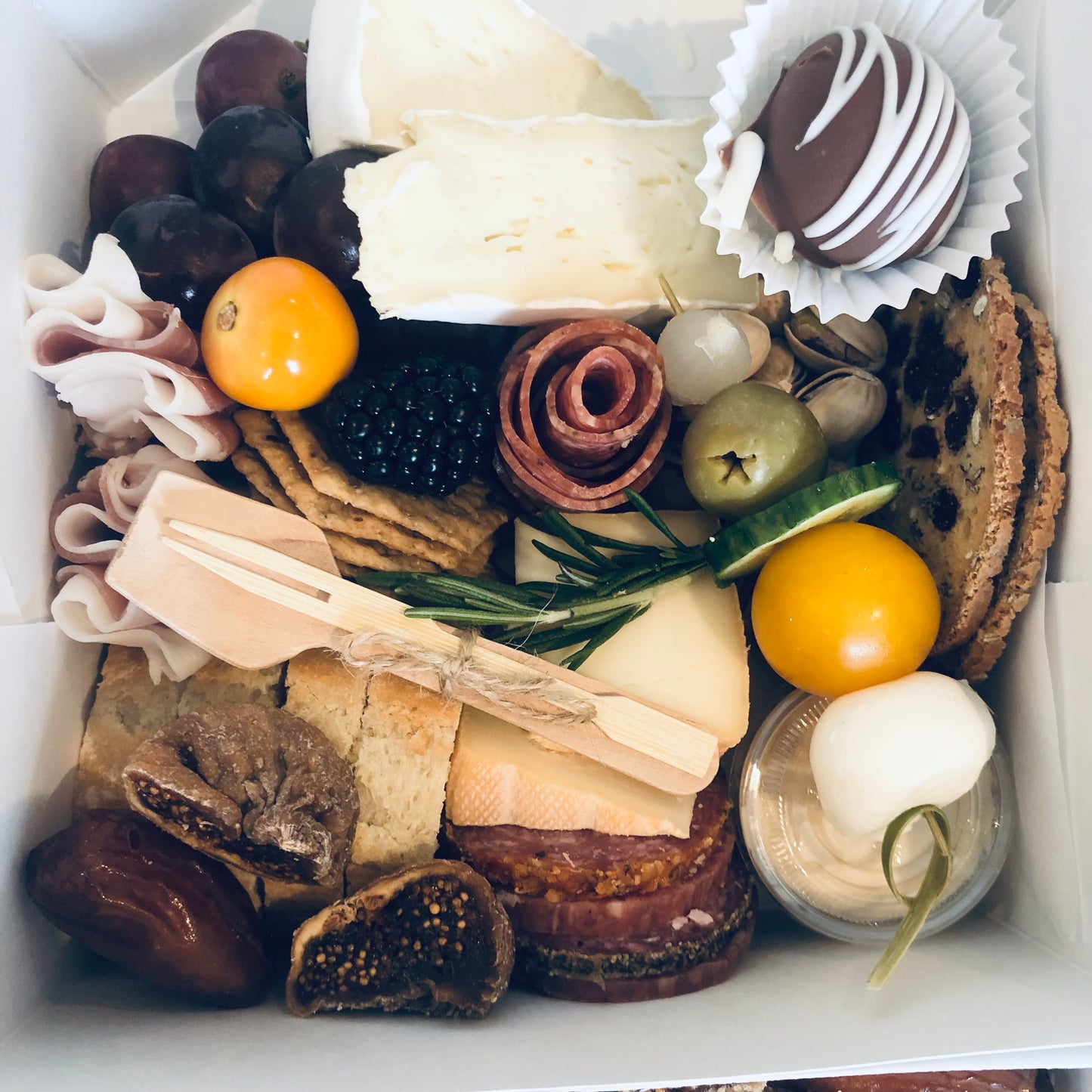  A typical individaul graze with 3 premium cheeses and charcuterie, fresh baguette, fresh and dried fruit, olives, pickles, compote, hummus and something sweet. 